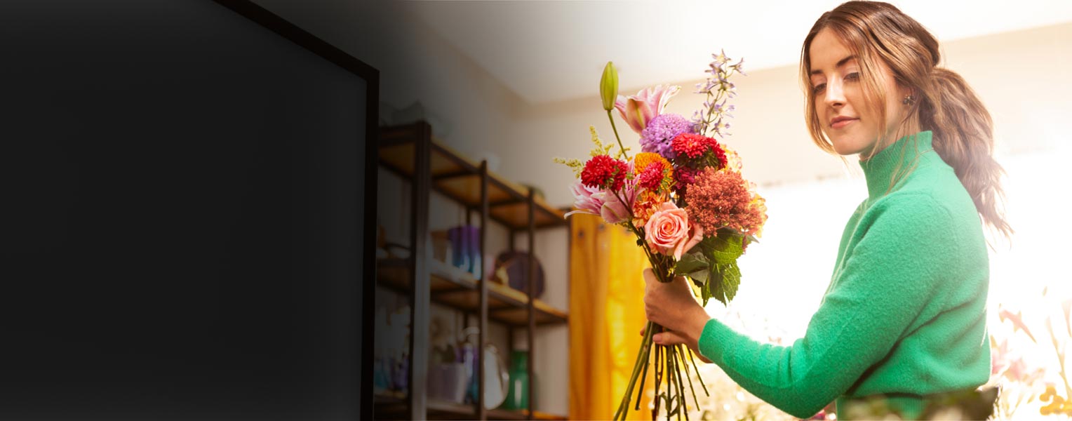 A person holding a vase filled with flowers.