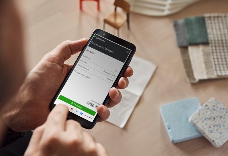 Man paying invoice on QuickBooks mobile app