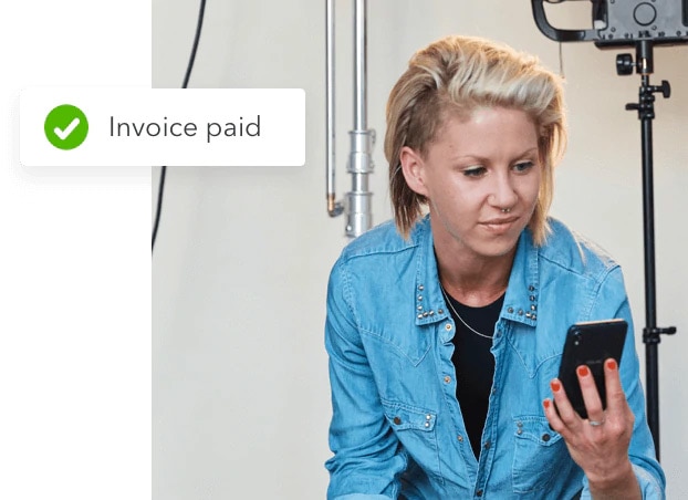 Business owner checking payment status of invoice on QuickBooks mobile app