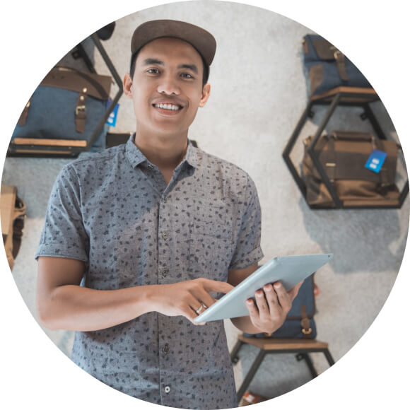 A person holding a laptop computer with a smile on his face.