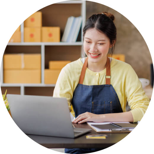 A person smiles as she holds a laptop.