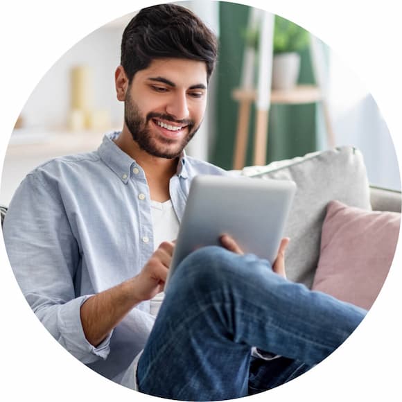 A person sitting on a couch with a laptop.