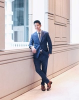 A person in a suit and tie standing in a doorway.