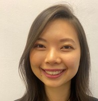 A person smiles while holding a card and a rose.