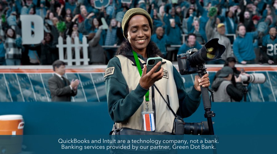 A sports photographer looking at QuickBooks Money on her smartphone