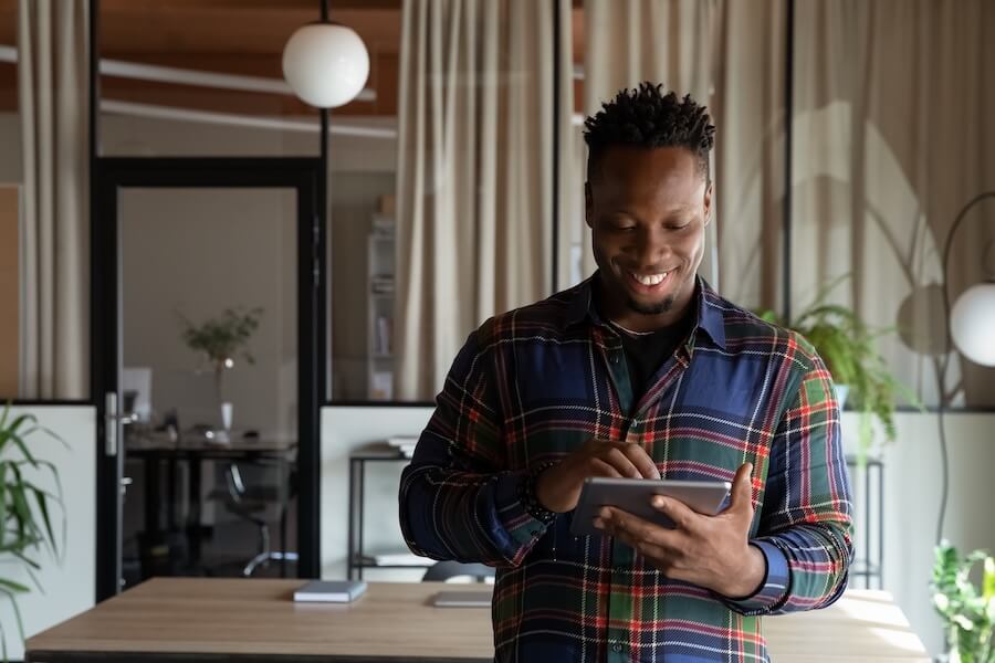 Business professional smiles and enters an order on his tablet.