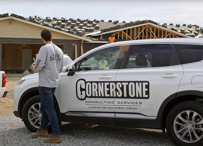 A person is working on a car that is being built.