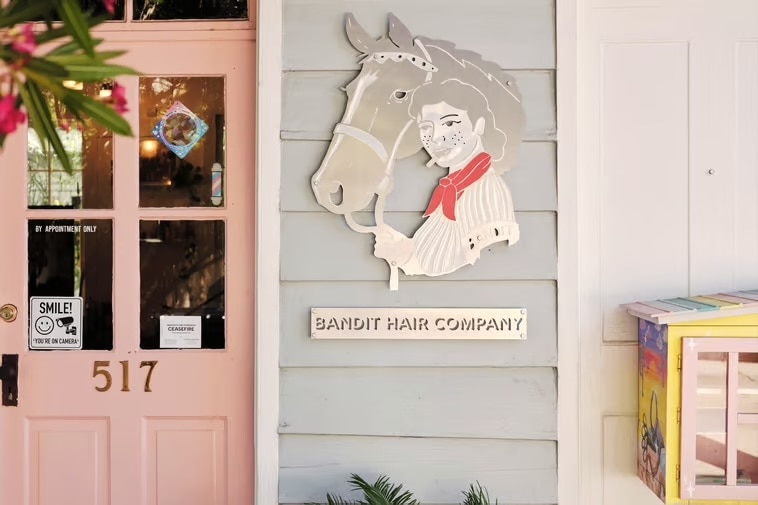 A store window with a picture of a horse and a sign for a horse salon.