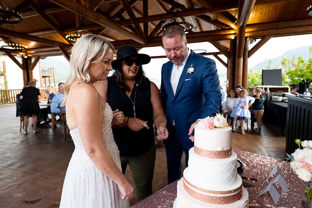 Taylor Strope and a couple looking at a wedding cake.