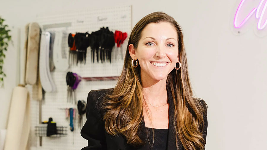 A person smiling while wearing a suit.