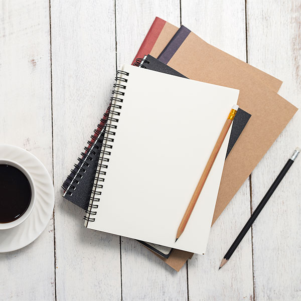Empty notebook and coffee on wooden table