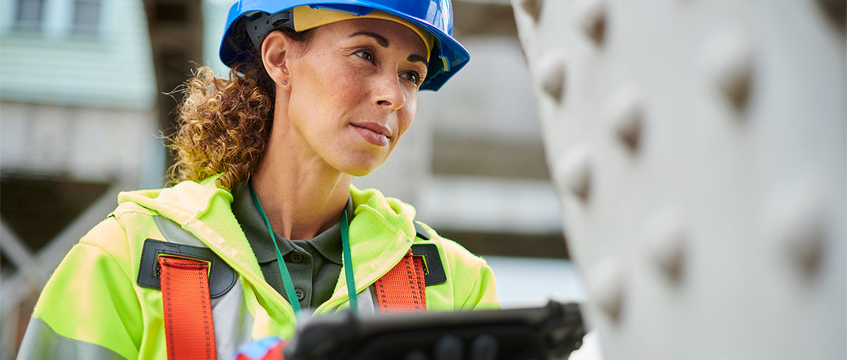 A person in a safety vest is working on a machine.