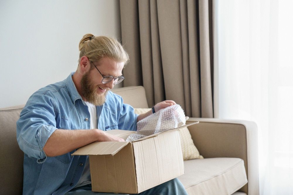 Man smiling while unboxing a package.