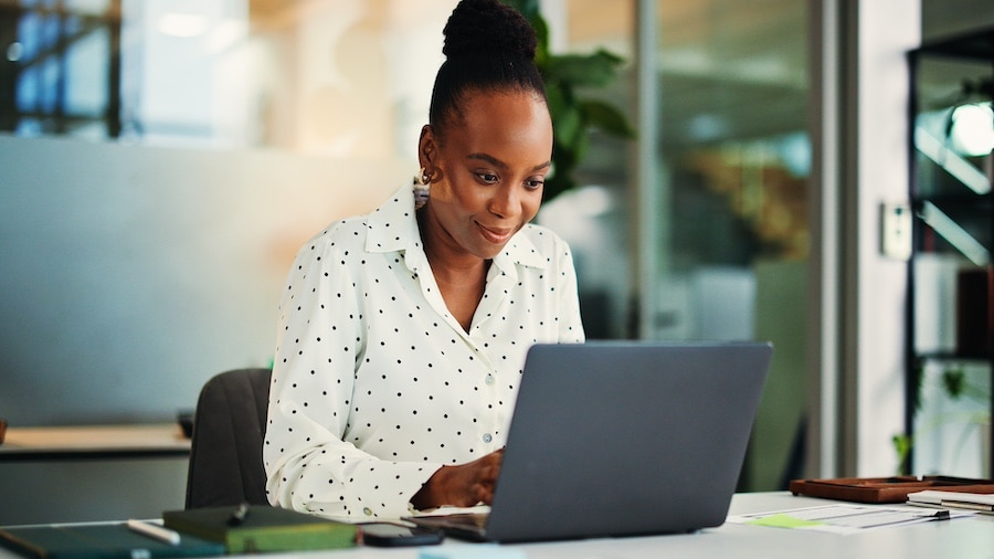 Person sitting at a desk looking at a laptop