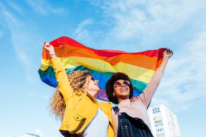 Two women waving a pride flag