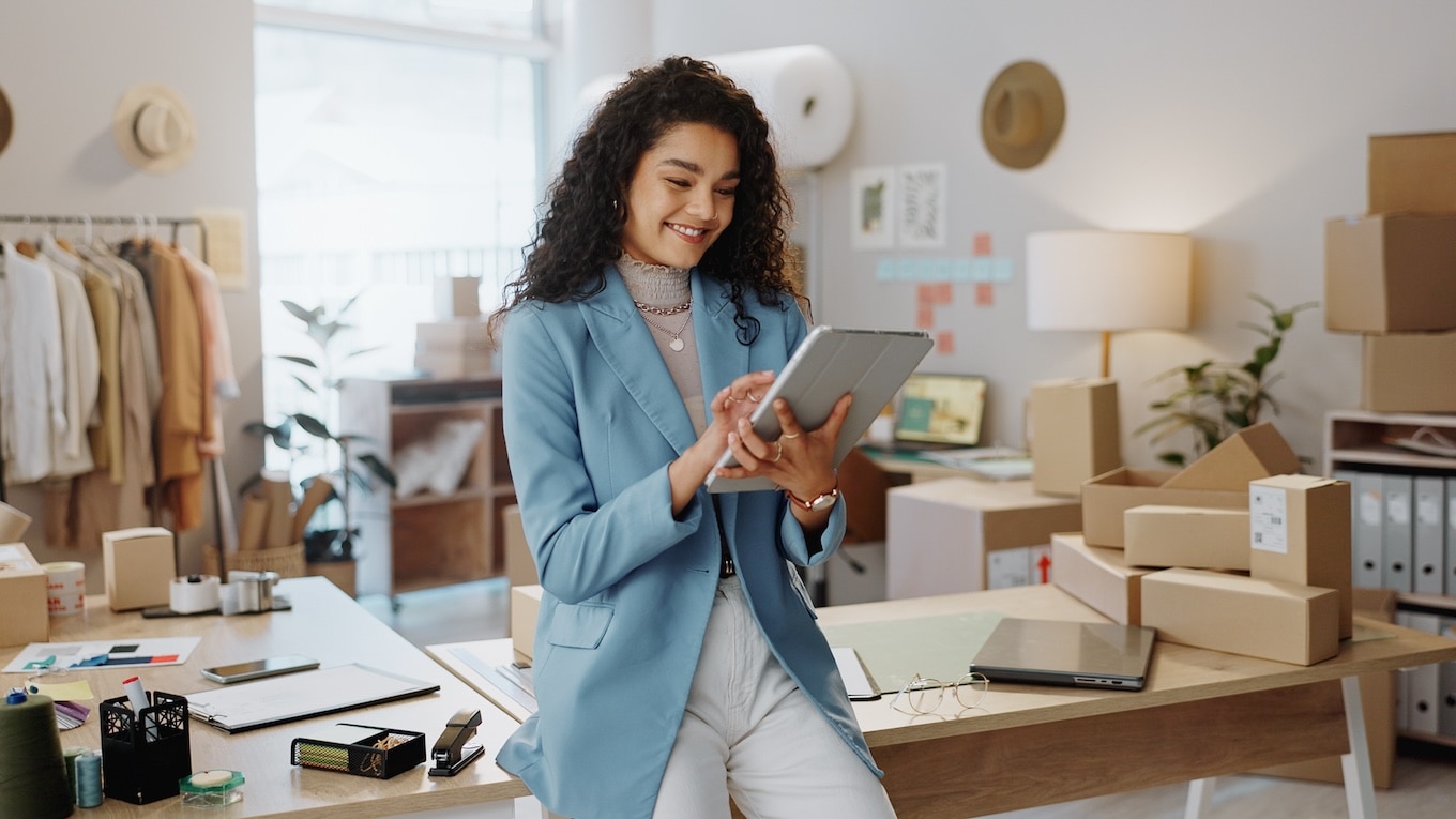 A person in a blue dress is holding a laptop.