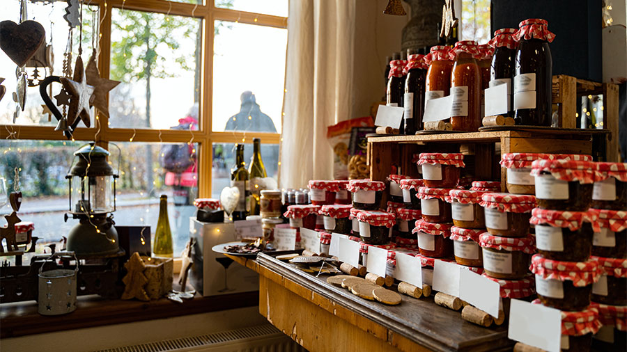Glass jars with natural homemade country jams and honey on counter of cozy shop 