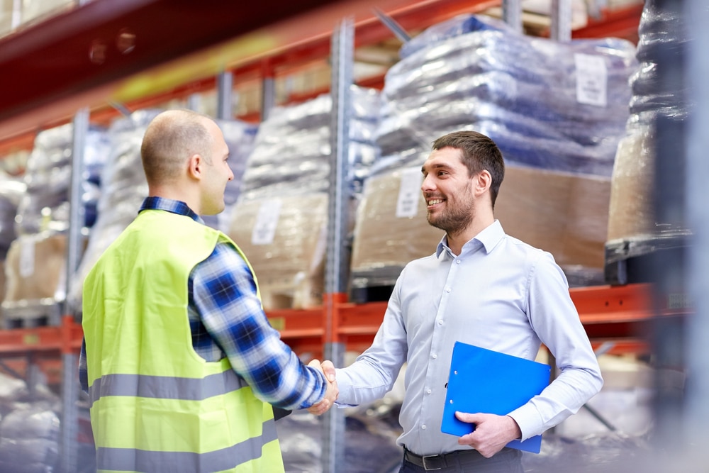 Image of a manager and warehouse employee shaking hands.