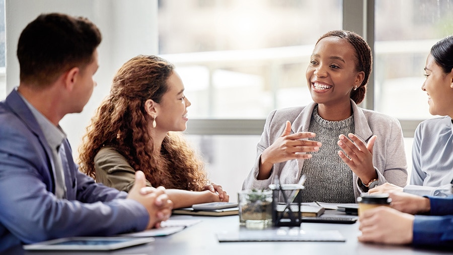 A group of employees talking around a table.