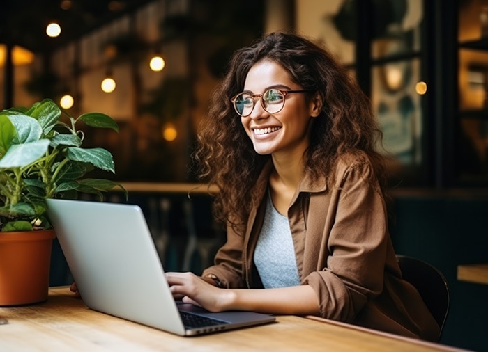 A person sitting at a table with a laptop reading about Intuit Assist.