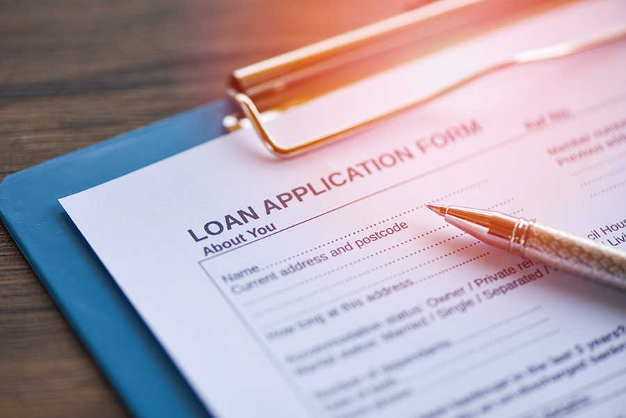 An image of a loan application form and a pen