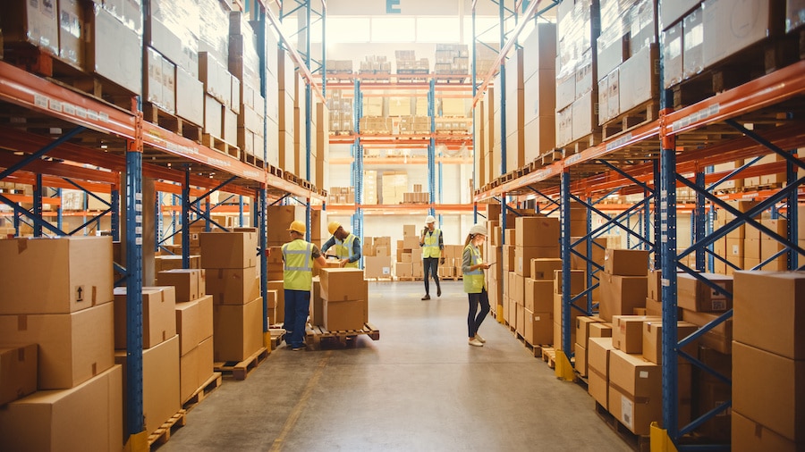 A warehouse filled with boxes and people standing around.