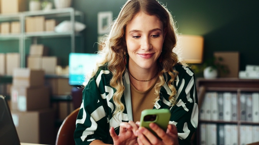 Woman using smartphone in modern office setting