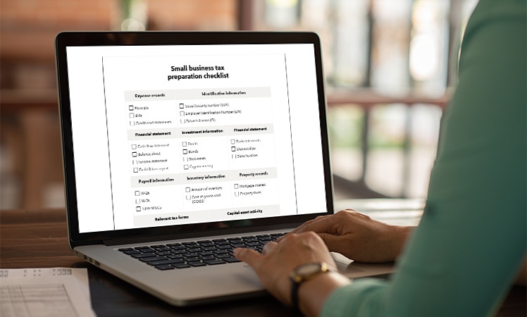 A person using the small business tax preparation checklist.