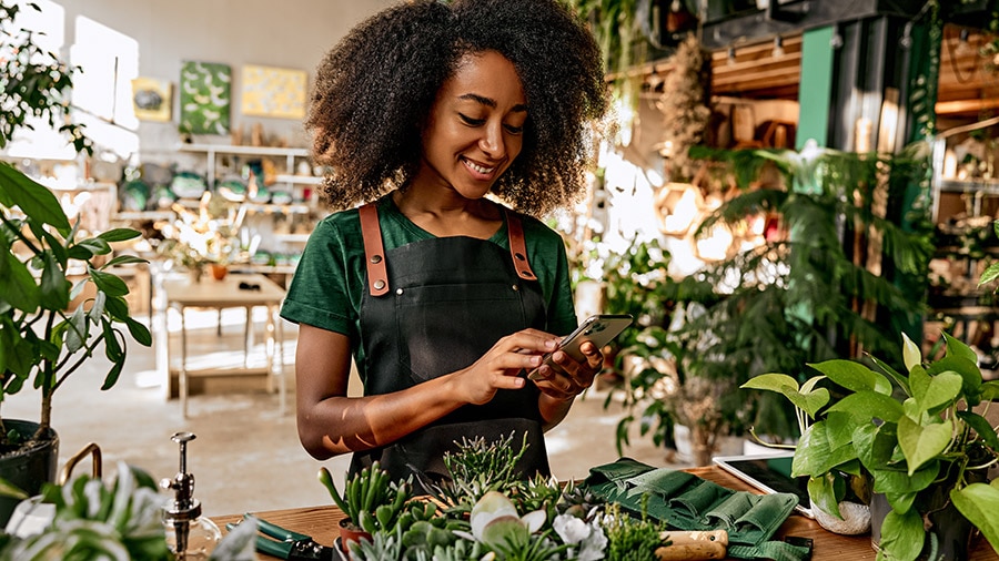 A person is sitting at a table with a cell phone.