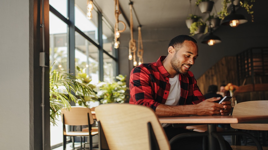 A person sitting at a table with a cellphone