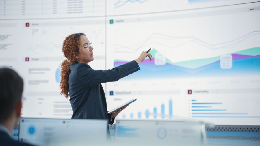 Businesswoman Analyzing Data on Large Digital Screens