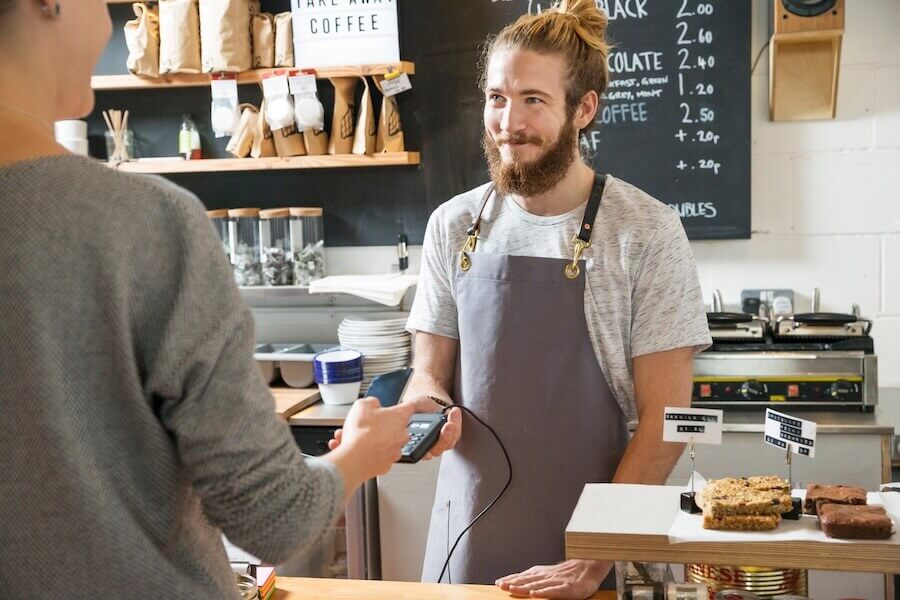 A customer making a contactless payment in a cafe.