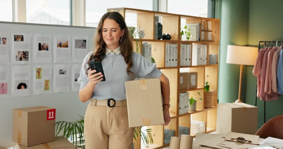 Business owner navigating with QuickBooks Mobile app on her phone.