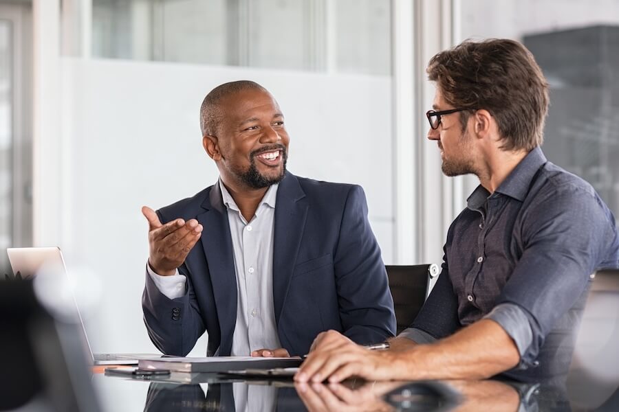 Two businessmen happily discussing QuickBooks Workforce.