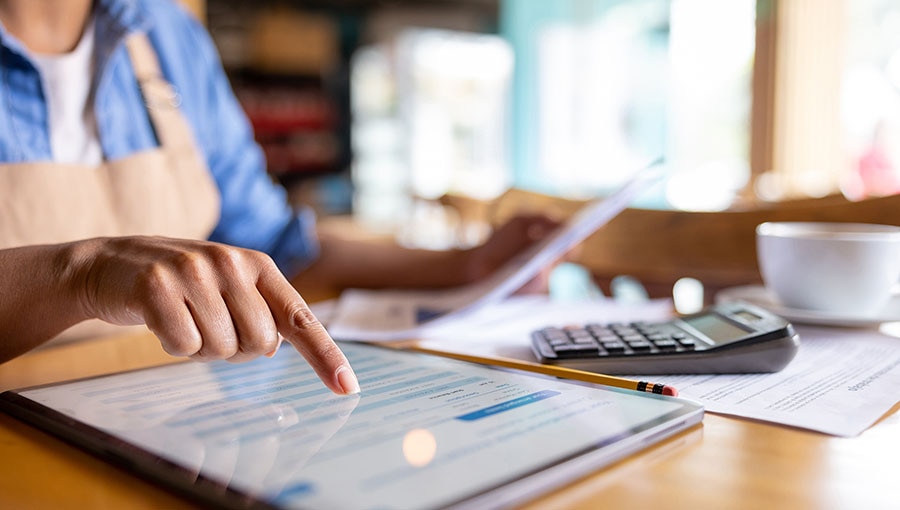 A business owner preparing a balance sheet on a tablet.