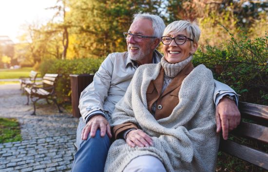 A person and person sitting on a bench.