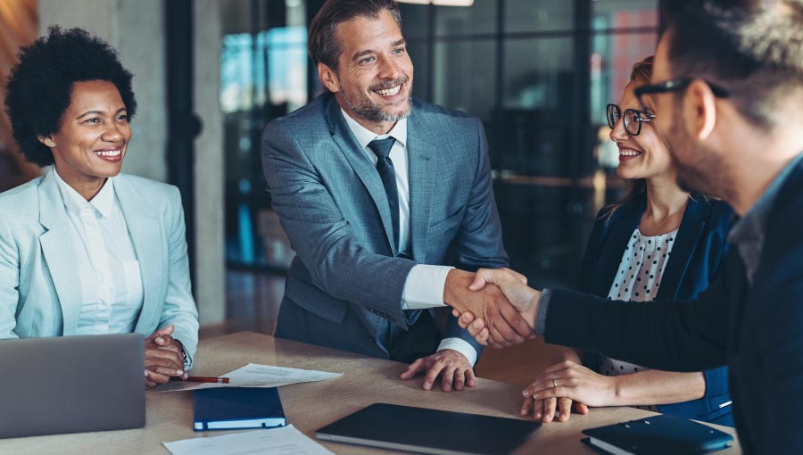 A photo showing business people shaking hands after a successful merger or acquisition.