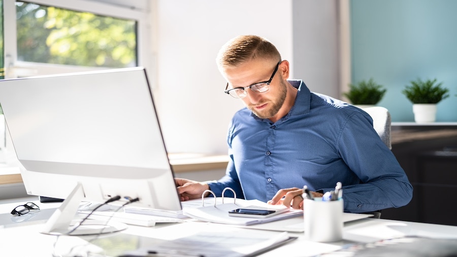 A person sitting at a desk with a laptop computer.