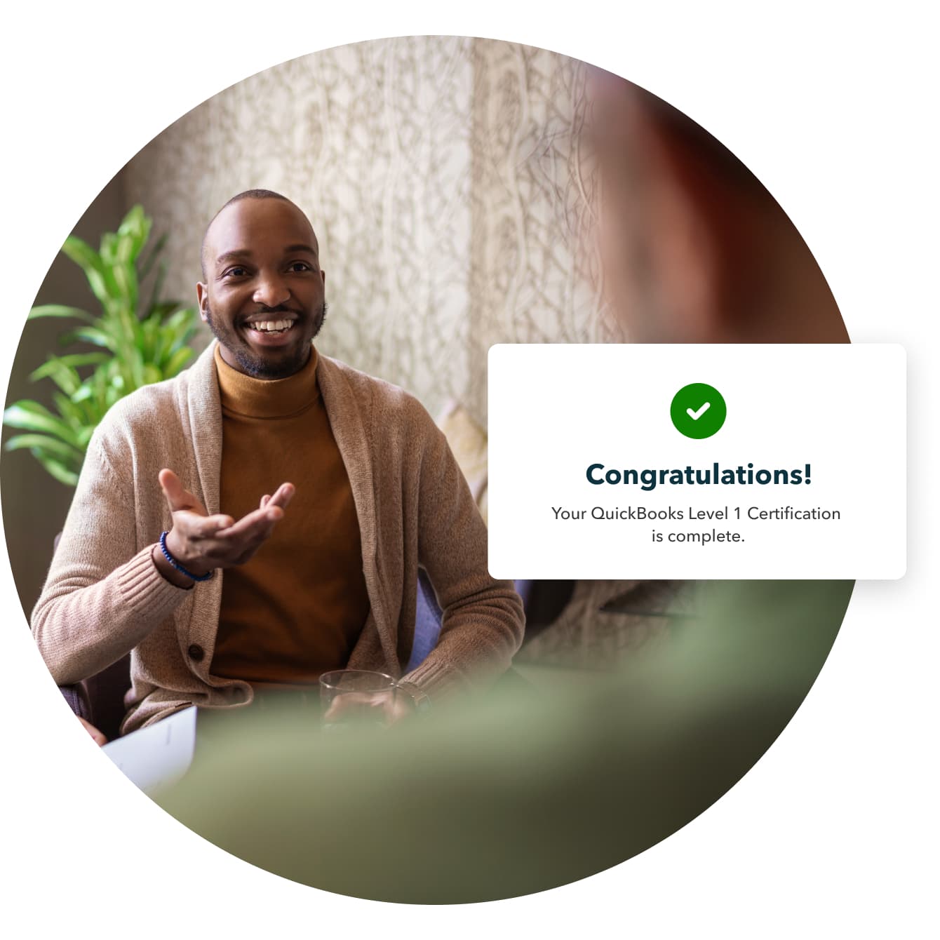 A smiling person holding a green glass with a picture of a person on it.