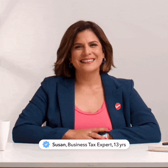 Two bakers stand in an industrial kitchen, smiling as they roll cookies, receives a message from bookkeeper, 'book cleanup almost finished!’