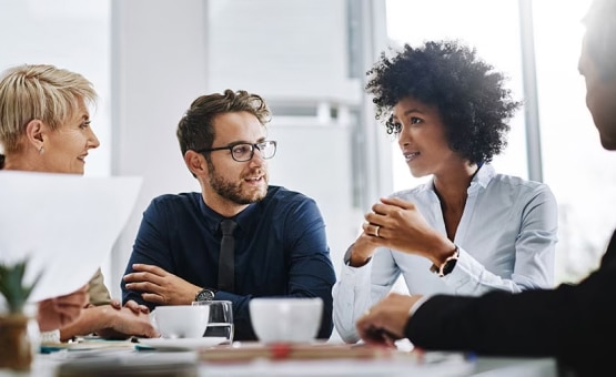 A photo of a group of people at a table talking.