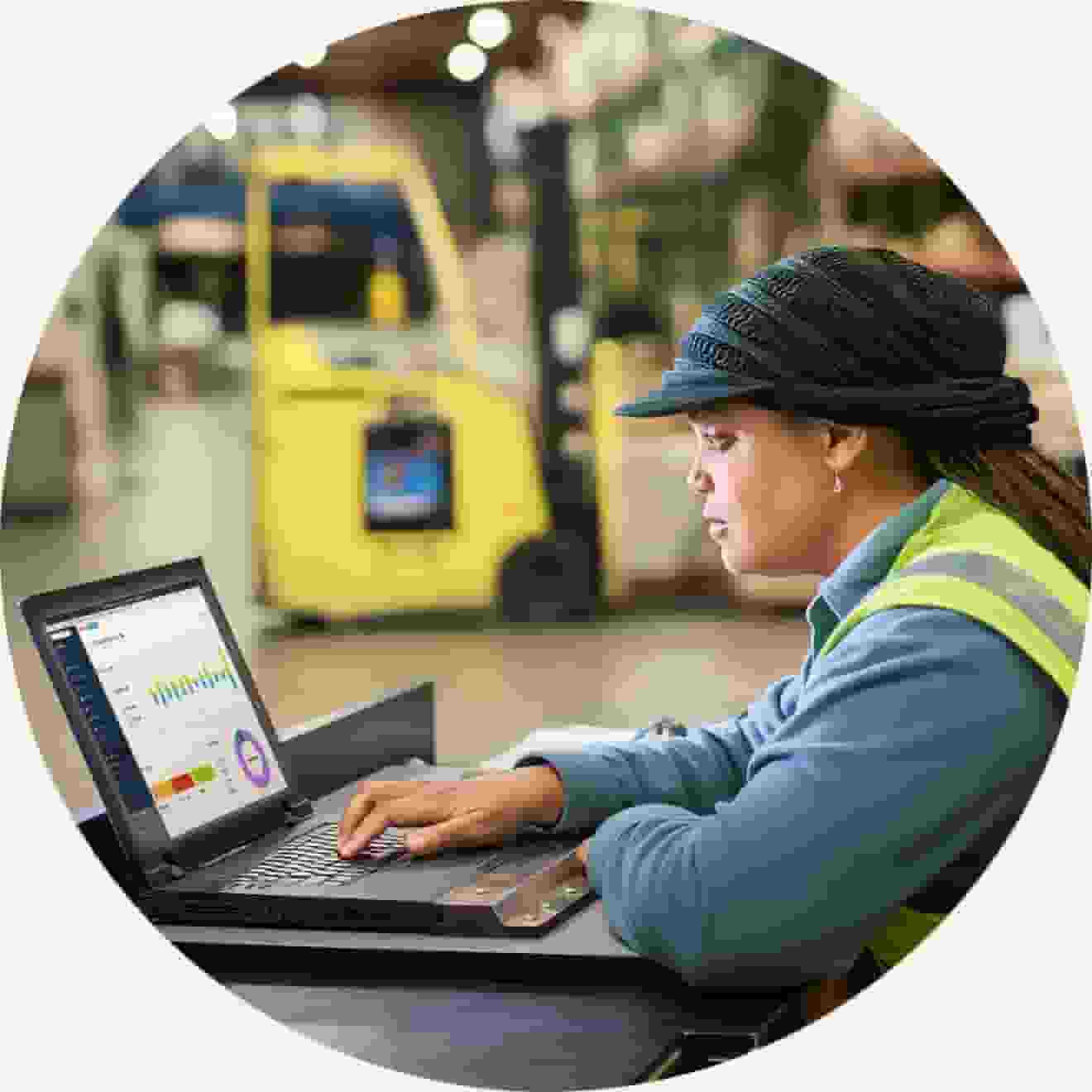 Female business owner in warehouse with laptop 