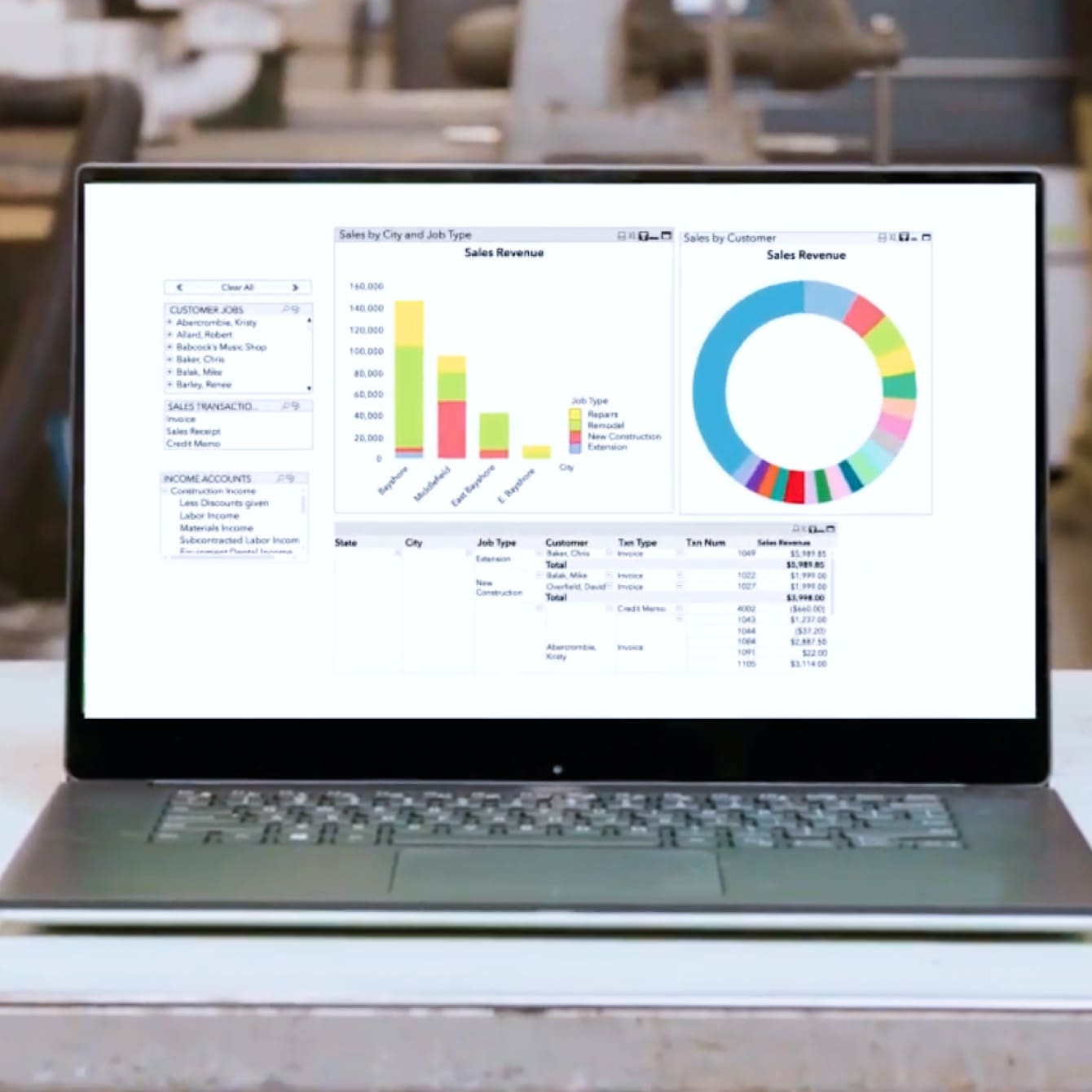 Laptop with QuickBooks Enterprise sales report on screen