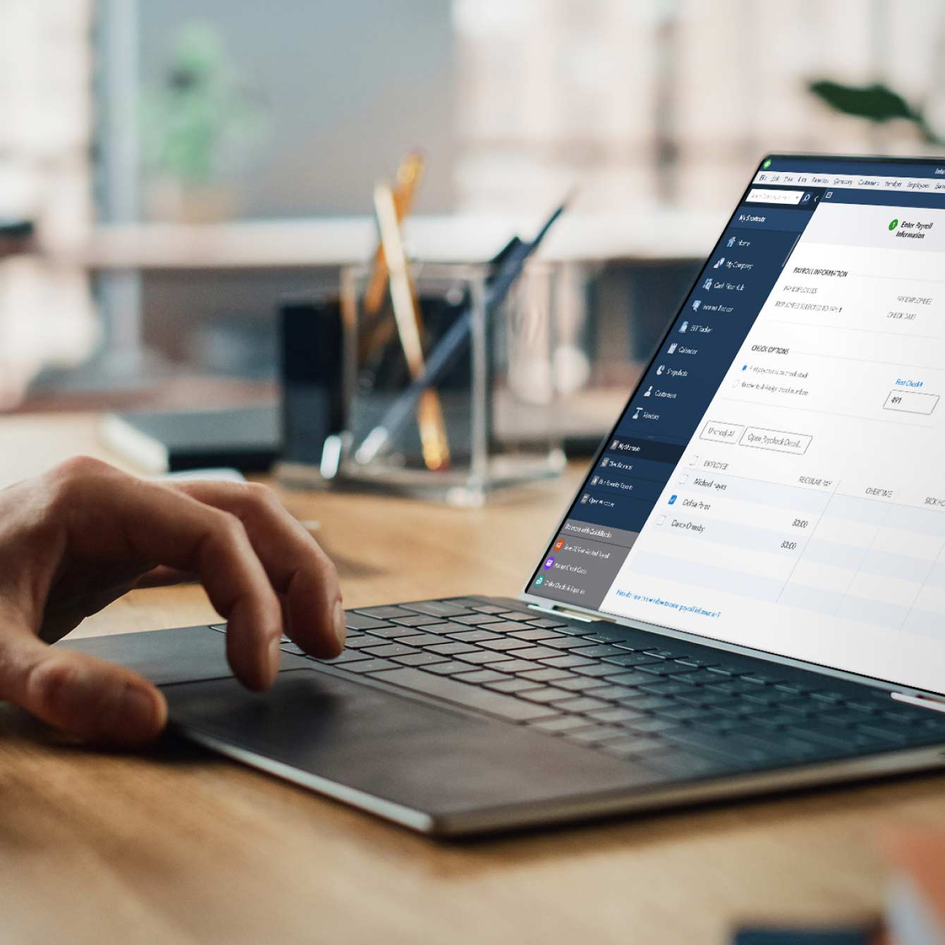 Person running payroll on laptop using QuickBooks Enterprise Diamond