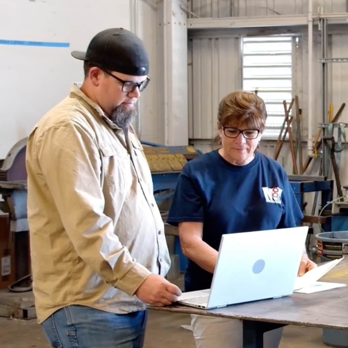Employees of Mathews Mechanical collaborating on a laptop