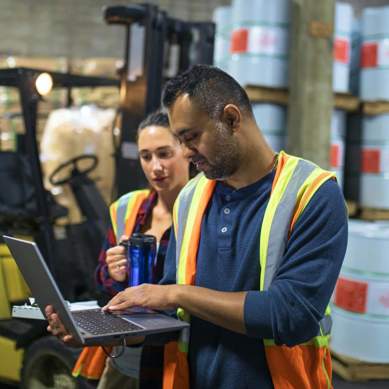 Woman and man in inventory warehouse looking at a laptop using QuickBooks Desktop Enterprise