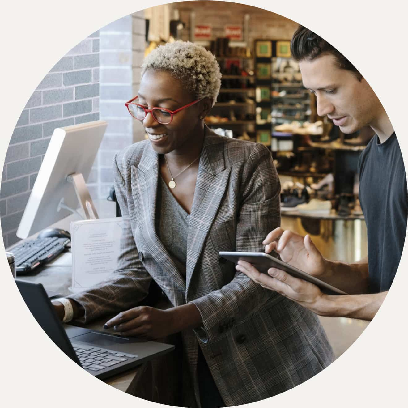 woman and man working on laptop and tablet in a retail store