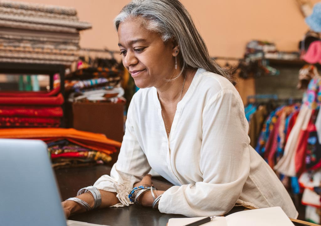 Woman on laptop using QuickBooks in retail store
