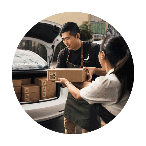 Two small-business owners packing orders into the back of their car to be delivered to customers.