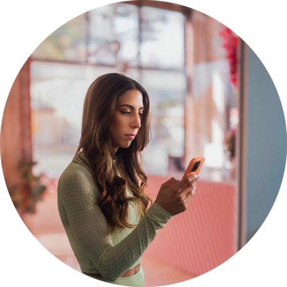 Personal trainer conducting business on a phone while in a gym studio.